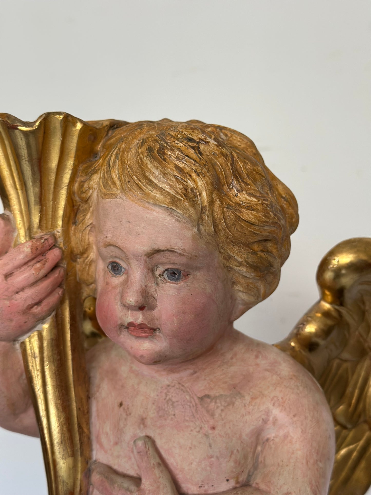 Angelo reggicornucopia in legno intagliato dorato. XVIII secolo.