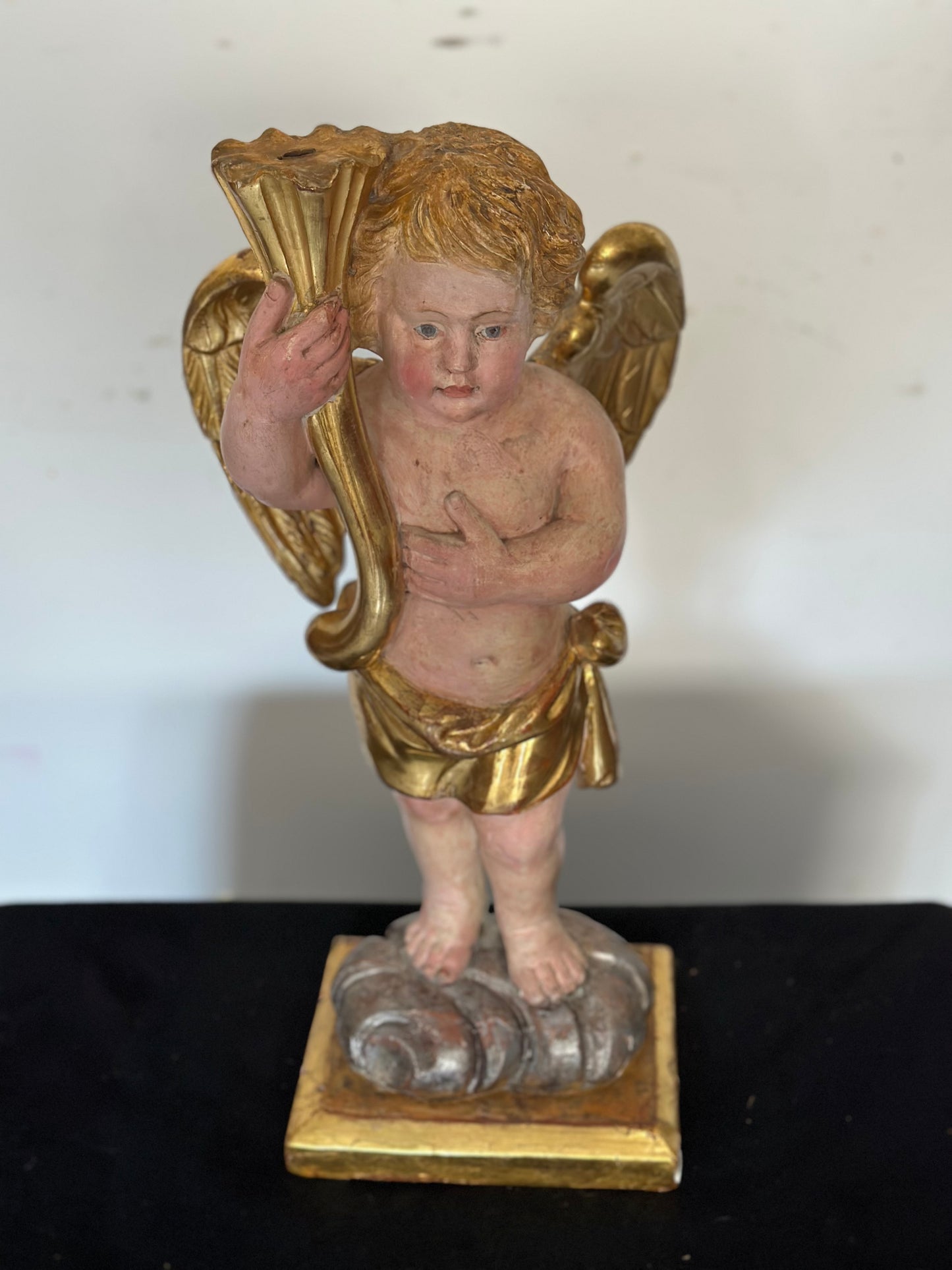 Angelo reggicornucopia in legno intagliato dorato. XVIII secolo.