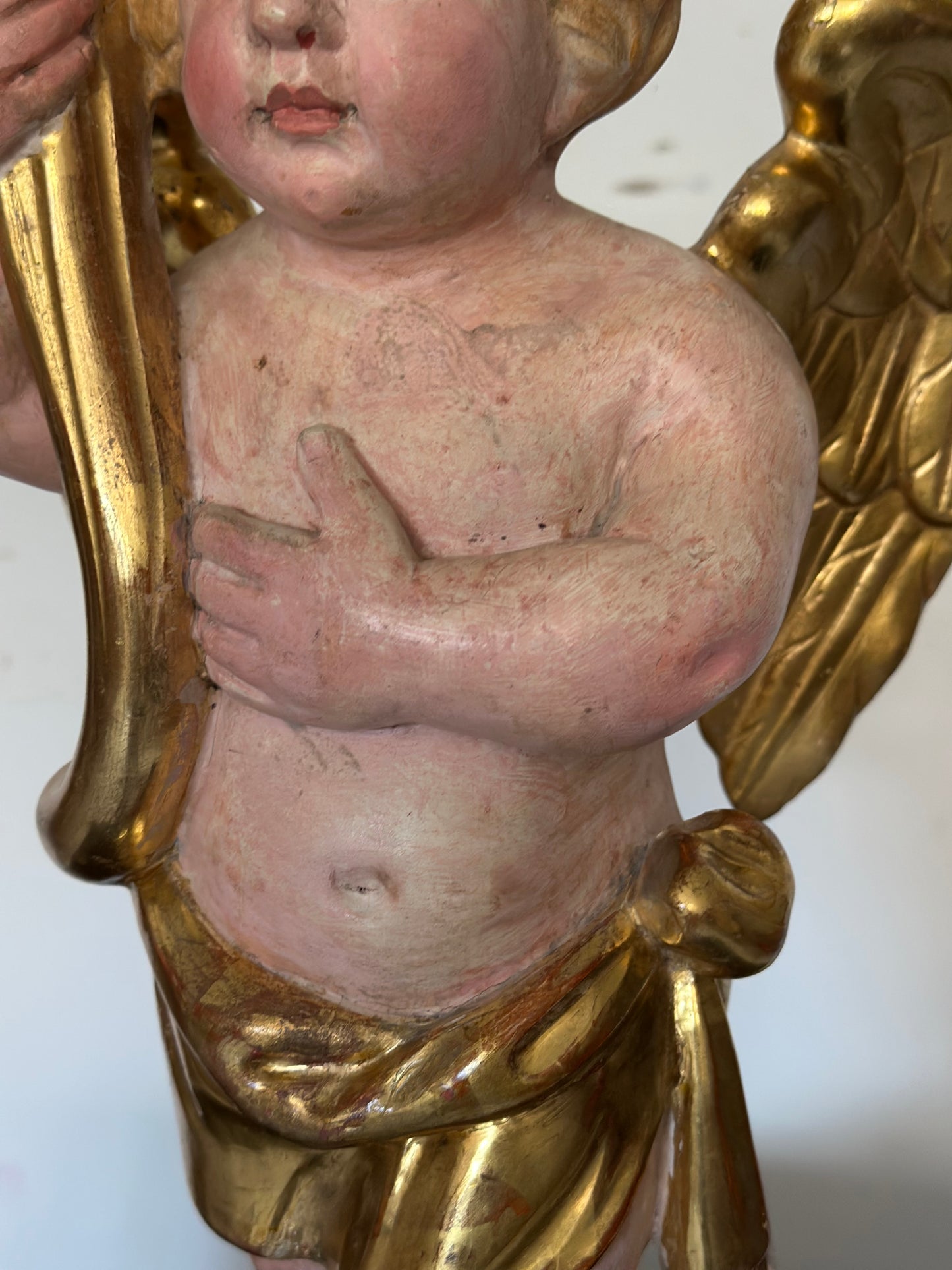Angelo reggicornucopia in legno intagliato dorato. XVIII secolo.