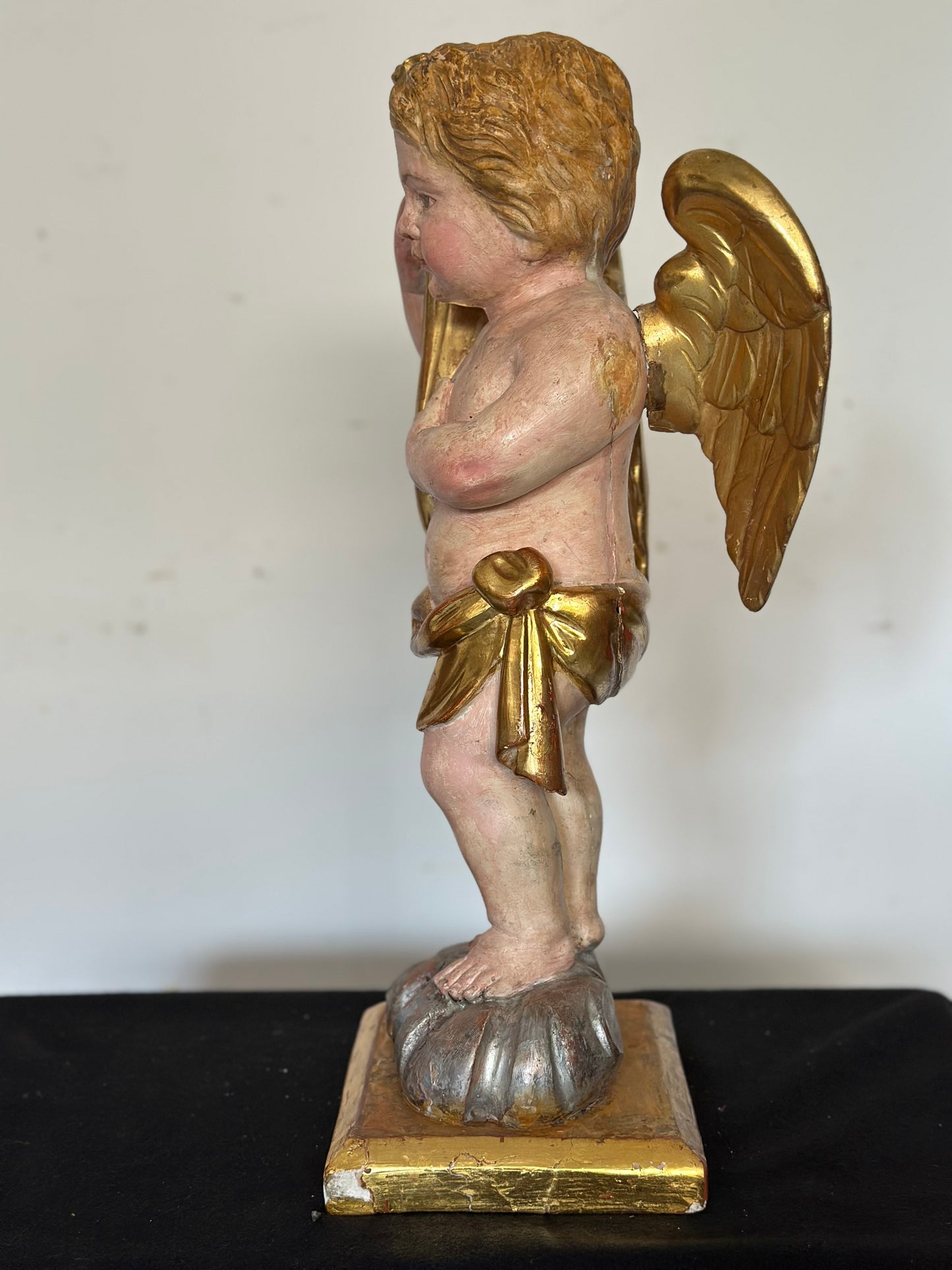 Angelo reggicornucopia in legno intagliato dorato. XVIII secolo.