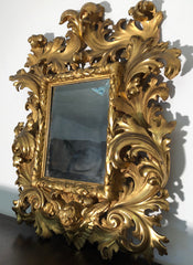 Specchiera a cartoccio in legno intagliato e dorato. Emilia fine XVII secolo
