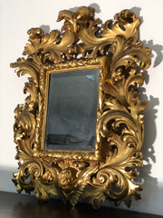 Specchiera a cartoccio in legno intagliato e dorato. Emilia fine XVII secolo