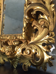 Specchiera a cartoccio in legno intagliato e dorato. Emilia fine XVII secolo