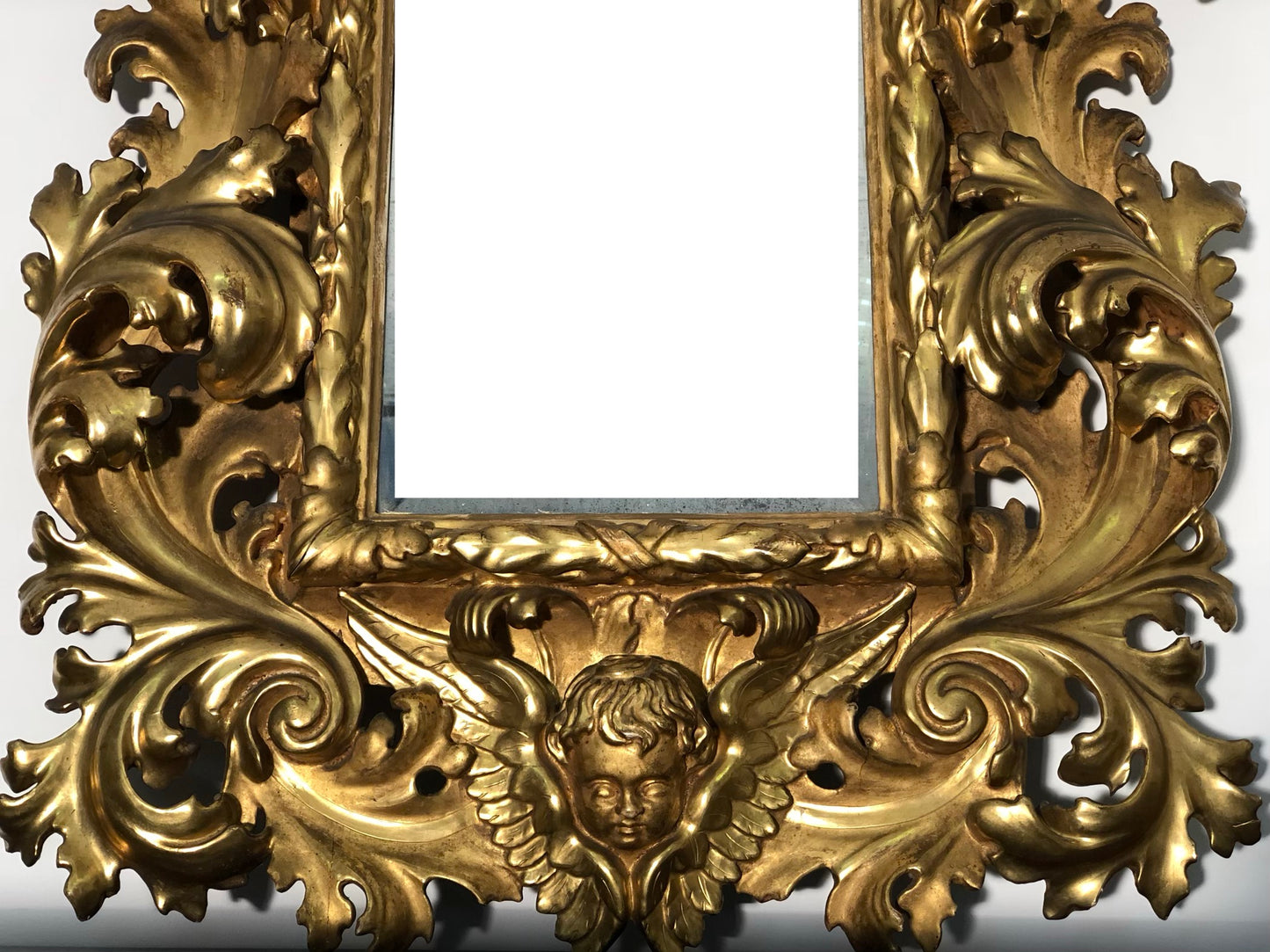 Specchiera a cartoccio in legno intagliato e dorato. Emilia fine XVII secolo