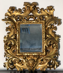 Specchiera a cartoccio in legno intagliato e dorato. Emilia fine XVII secolo