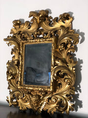 Specchiera a cartoccio in legno intagliato e dorato. Emilia fine XVII secolo