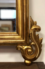 Specchiera l’oro zecchino intagliata a motivi floreali .