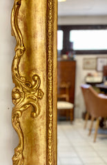 Grande specchiera lombarda in legno intagliato dorato a foglia . XIX secolo