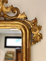 Specchiera l’oro zecchino intagliata a motivi floreali .