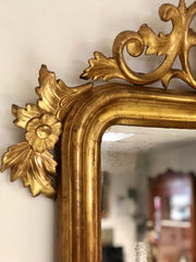 Specchiera l’oro zecchino intagliata a motivi floreali .