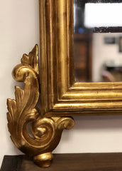 Specchiera l’oro zecchino intagliata a motivi floreali .