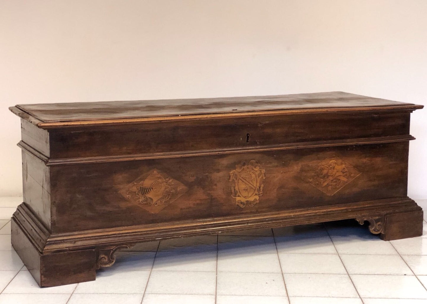 Cassapanca emiliana in noce con stemmi nobiliari intarsiati sul fronte. XVII secolo