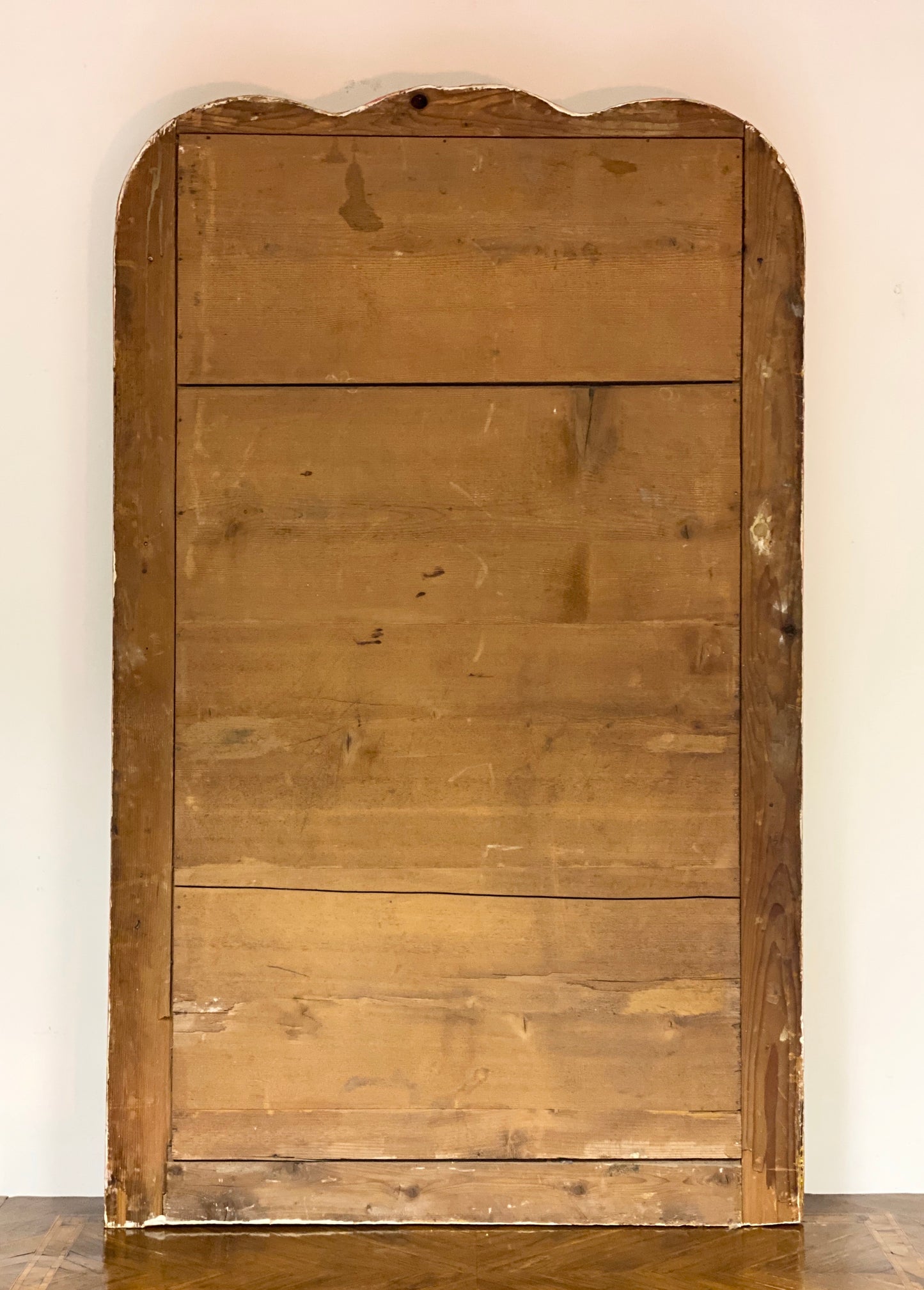 Gilded wooden mirror with shaped top. Early 19th century