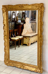 Grande specchiera lombarda in legno intagliato dorato a foglia . XIX secolo