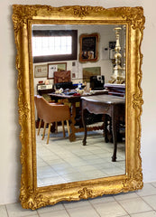 Grande specchiera lombarda in legno intagliato dorato a foglia . XIX secolo