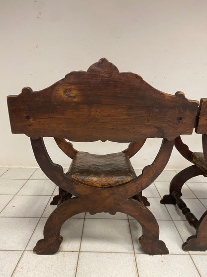 Coppia di poltrone Savonarole in noce scolpite. XVII secolo