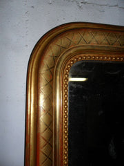 Specchiera caminiera in oro zecchino. Vetro al mercurio.