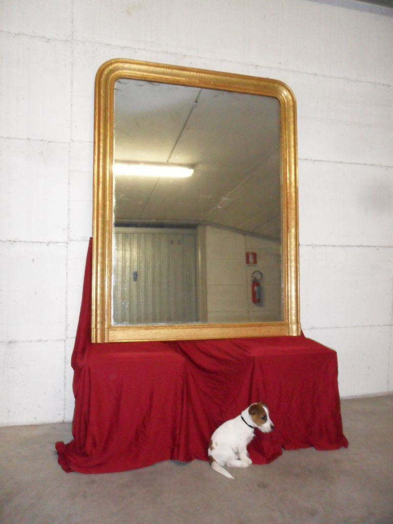 Specchiera caminiera in oro zecchino. Vetro al mercurio.