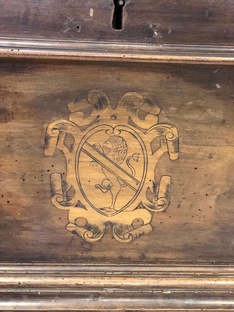 Cassapanca emiliana in noce con stemmi nobiliari intarsiati sul fronte. XVII secolo
