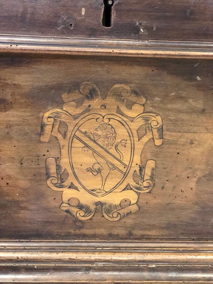 Cassapanca emiliana in noce con stemmi nobiliari intarsiati sul fronte. XVII secolo
