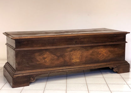 Cassapanca emiliana in noce con stemmi nobiliari intarsiati sul fronte. XVII secolo