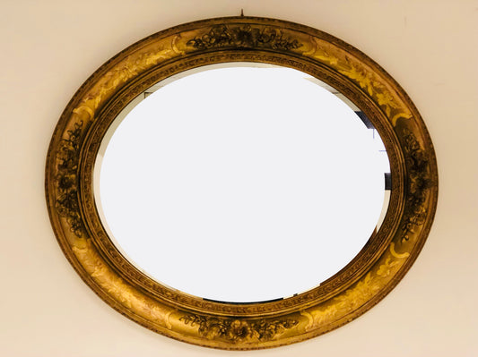 Oval mirror in carved and gilded wood